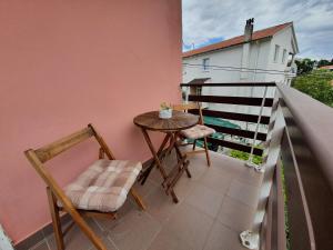 a small table and two chairs on a balcony at Apartment Padova I and II in Rab