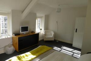 a bedroom with a desk with a television and a chair at Totters townhouse in Caernarfon
