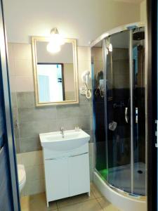 a bathroom with a white sink and a shower at Zajazd Fakir in Tapkowice +19 photos