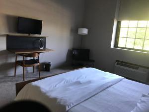 a bedroom with a television and a bed at The Roundhouse in Beacon