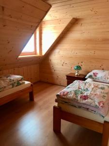 a bedroom with two beds in a wooden cabin at Serce Beskidu Niskiego in Świątkowa Mała