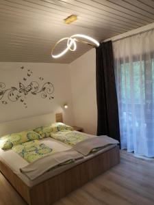 a bedroom with a bed with a chandelier above it at Gasthof Liebetegger in Moosburg