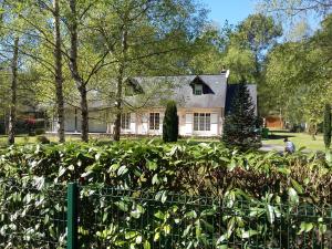 uma casa com uma sebe à sua frente em B&B La Forêt de Charmeuse em Ruaudin