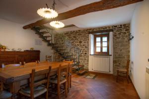 uma sala de jantar com uma mesa de madeira e cadeiras em Agriturismo Il Corniolo em Castiglione di Garfagnana
