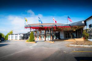 a building with flags on the front of it at Hotel La Caravelle in Baie-Comeau