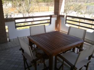 een houten tafel en 2 stoelen op een patio bij COUNTRY HOUSE in Mafalda