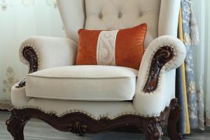 a white chair with an orange pillow on it at Min Le Yuan B&B-include long stay in Hualien City