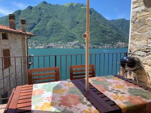 a table with an umbrella on top of a balcony at La Casa del Mastro - Como Lake in Pognana Lario