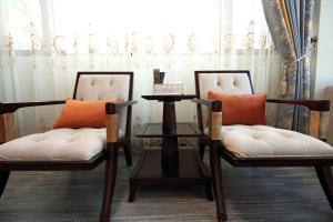two chairs and a table in a room at Min Le Yuan B&B-include long stay in Hualien City