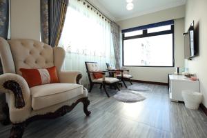 a living room with a chair and a large window at Min Le Yuan B&B-include long stay in Hualien City