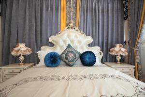 a bedroom with a white bed with blue pillows at Min Le Yuan B&B-include long stay in Hualien City