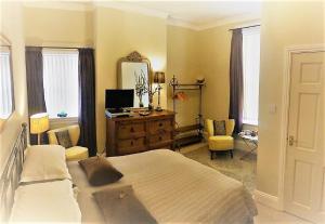 布里德灵顿The Villa Bridlington的带床、梳妆台和镜子的卧室