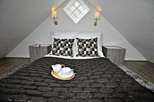 a bedroom with a bed with a plate with two tea pots on it at Apartamenty Katarynka Stary Rynek in Bydgoszcz