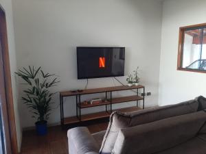 a living room with a tv and a couch at Space Universe Pinda, Taubaté, Aparecida, Campos do Jordāo in Pindamonhangaba
