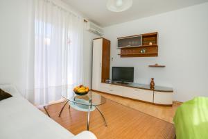 uma sala de estar com um sofá e uma mesa de vidro em Apartments Gracijela em Pula