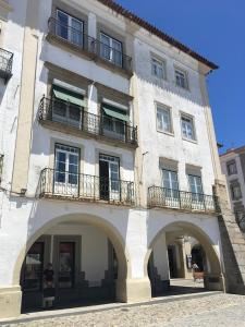 a large white building with two balconies on it at Casa do Giraldo in Évora