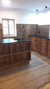 uma cozinha com armários de madeira e um lavatório num quarto em Plötzhof em Hof bei Salzburg