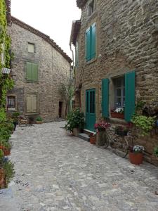 a stone alley with a bike parked next to a building at Gite les Volets Verts in Cesseras