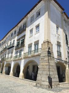 a large white building with a clock in front of it at Casa do Giraldo in Évora