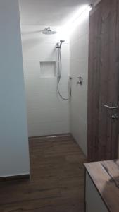 een badkamer met een douche in een witte muur bij Plötzhof in Hof bei Salzburg