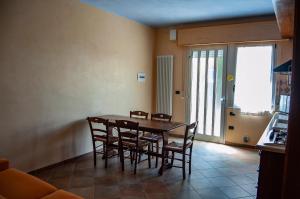 una sala da pranzo con tavolo e sedie in legno di Appartamenti Corallo ad Alba Adriatica Altre 25 foto