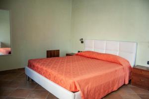 アルバ・アドリアティカにあるAppartamenti Coralloのベッドルーム1室(大型ベッド1台、オレンジ色のベッドカバー付)