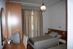 a hotel room with a bed and a desk and a television at Albergo Amici in Varese Ligure