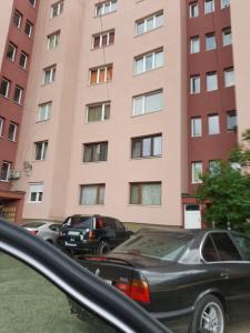 um carro estacionado em frente a um edifício cor-de-rosa em Apartment Milevi em Teteven
