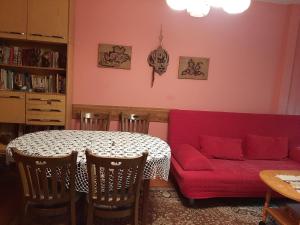 sala de estar con mesa y sofá rojo en Apartment Milevi, en Teteven