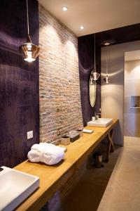 AnthenayにあるFerme du Châteauのレンガの壁、洗面台2台付きのバスルーム