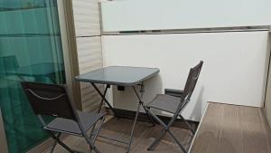 duas cadeiras e uma mesa num quarto em TC Hotel Doña Luisa em Las Palmas de Gran Canaria