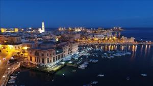 a city at night with boats in the water at Kaktus B&B in Bari