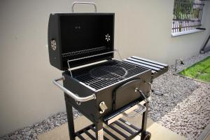 a grill sitting on a cart in a yard at Jazmin apartmány in Veľký Meder