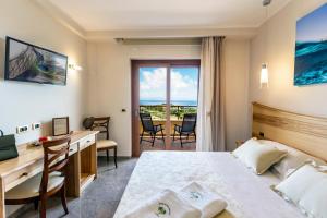 a hotel room with a bed and a desk and a desk at Hotel Santa Chiara in Capo Vaticano