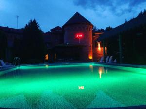 a swimming pool at night with a building with a clock at Britaniya in Kharkiv