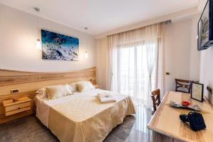 a hotel room with a bed and a desk at Hotel Santa Chiara in Capo Vaticano