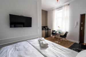 a bedroom with a bed with a flat screen tv on the wall at Ara Apartamenty in Toruń