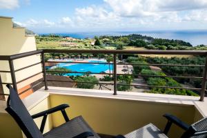 a balcony with a view of a pool and the ocean at Hotel Santa Chiara in Capo Vaticano
