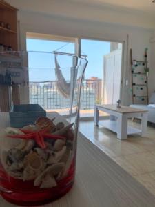 a glass vase filled with shells on top of a table at Apartamento primera línea de Mar Enjoy the view in Blanes