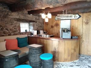 a bar in a restaurant with a counter and stools at Chambres d'hôtes La Fontaine in Espalion