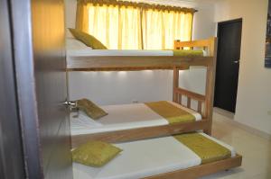 three bunk beds in a room with a window at Casa Hotel Manga Mar in Cartagena de Indias