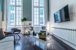 a living room with a couch and a tv at Family Apartments San Lorenzo in Genova +22 photos