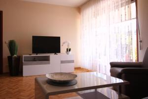 een woonkamer met een tv en een tafel bij Ferienwohnung Sonneck in Bullay