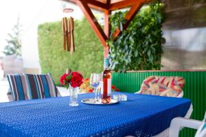 a blue table with a bottle of wine and a glass at Martha Apartman in Bük