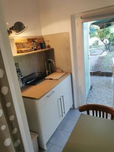 eine kleine Küche mit einem Waschbecken und einem Tisch in der Unterkunft Studio de charme en Provence in Le Luc