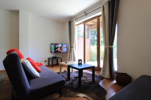 a living room with a couch and a table and a window at Family Apartment HIRSCH in Bad Kleinkirchheim