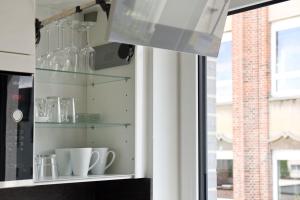 a shelf with glass bottles and cups on a window at City Appartement Kornwestheim in Kornwestheim