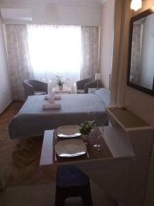 Habitación de hotel con cama, mesa y TV en Sylvia' s Apartments en Atenas