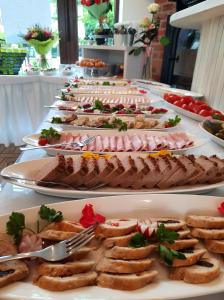 a buffet with many plates of food on a table at PIONOW Pokoje WaWa - adults only in Krynica Morska