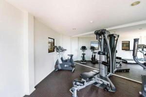 einen Fitnessraum mit mehreren Laufbändern und Heimtrainern in der Unterkunft Accommodation Sydney City Centre - Hyde Park Plaza Park View College Street Studio Apartment in Sydney